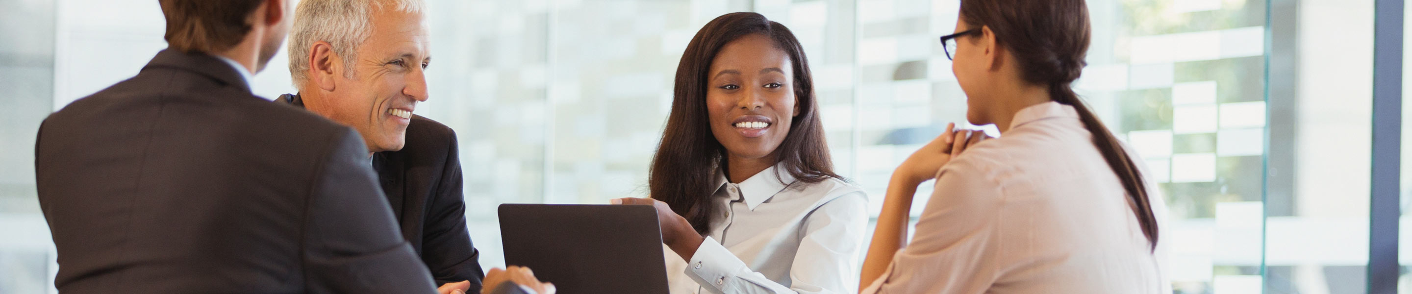 Équipe de travail discutant de services professionnels avec un ordinateur portable.